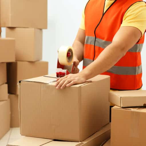 Operaio con gilet ad alta visibilità che prepara scatole di cartone